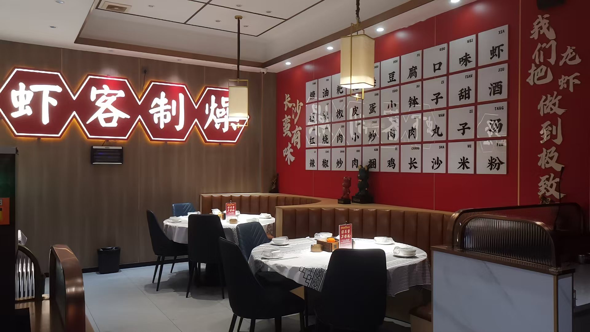 店内大厅圆桌用餐区，红墙与新中式吊灯