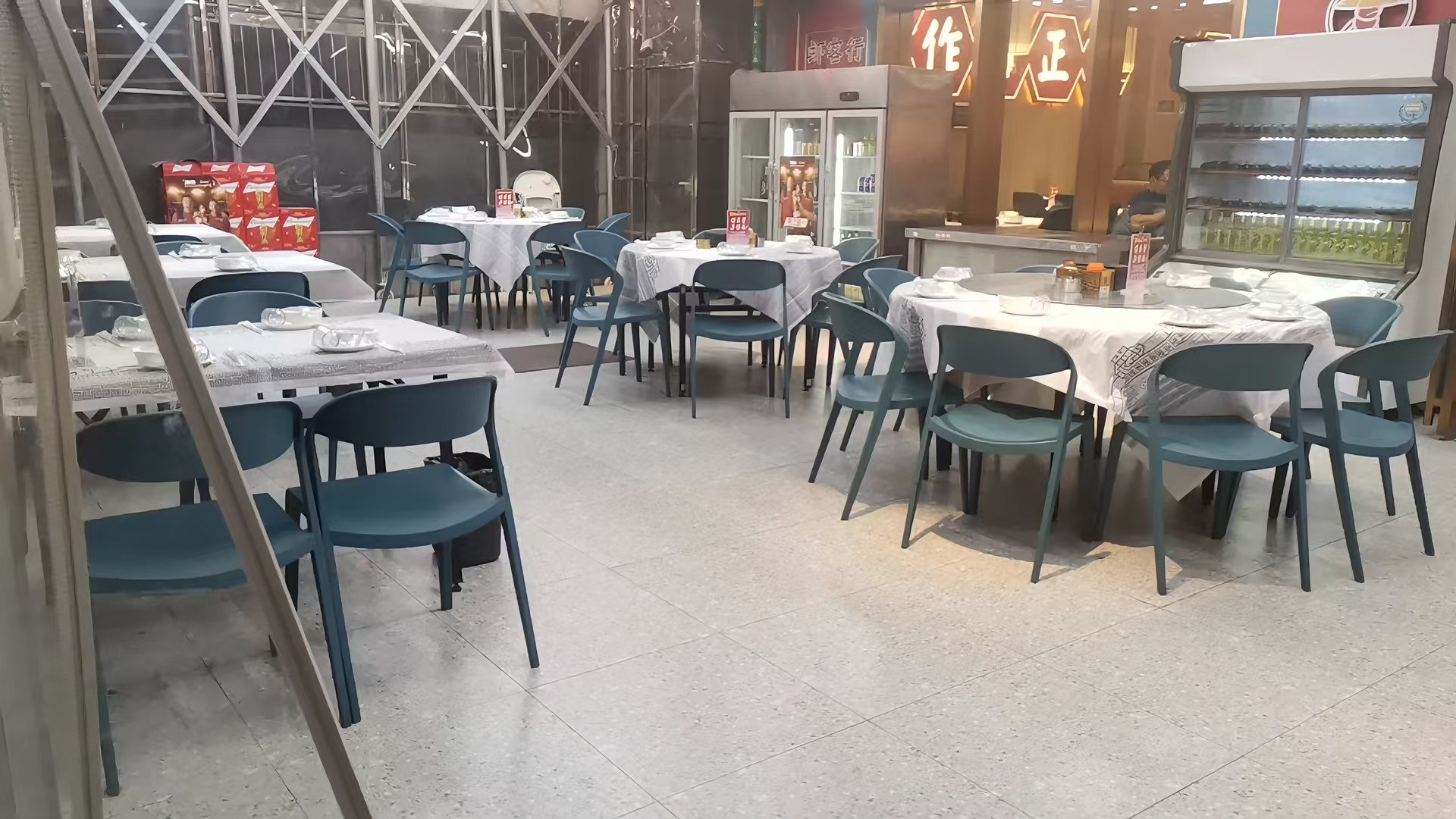 带伸缩雨棚的店外露天外摆用餐区，圆桌整齐摆放
